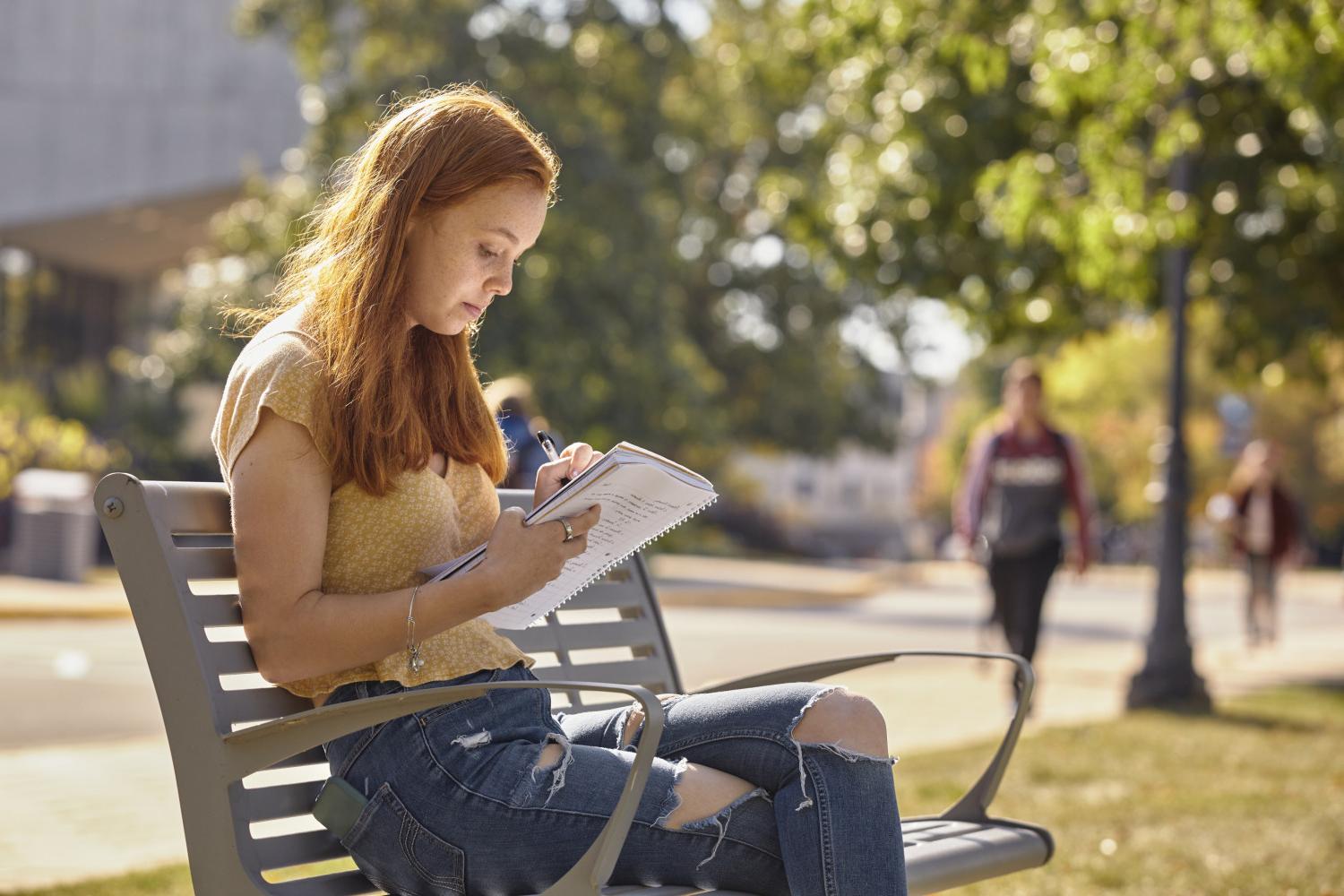 A <a href='http://ciqdcv7o.dfh17.com'>全球十大赌钱排行app</a> student reads on a bench along Campus Drive.